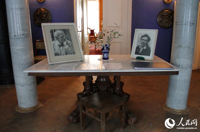 На столе на синем фойе лежат фотографии Станиславского и его жены Марии Лилиной.