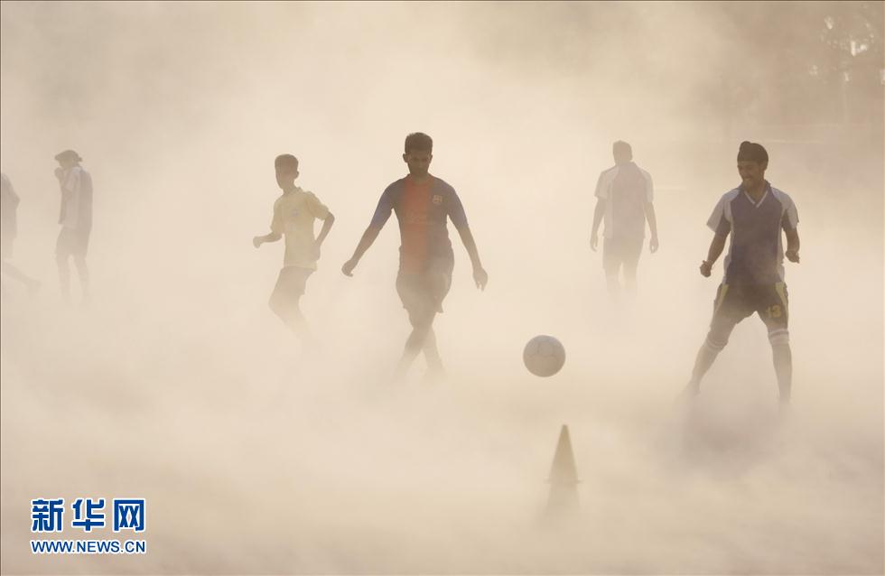 11 июня в индийском штате Джамму несколько молодых людей, несмотря на песчаную бурю, играют в футбол. ИА «Синьхуа»/АР