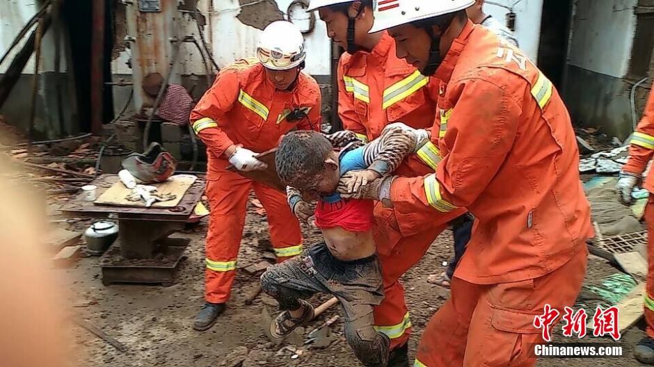 На фото: Пожарная команда выкапывает ребенка из-под развалов.