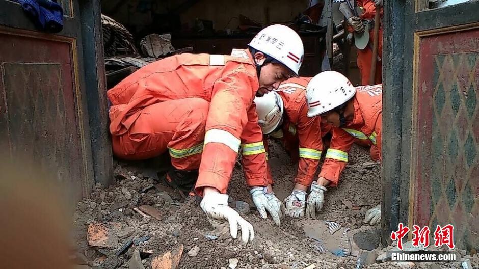 Землетрясение в Юньнане: Пожарная команда вытаскивает ребенка из-под развалов
