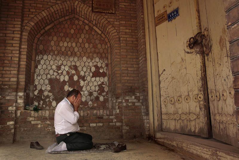 Мужчина молится в старом районе города Кашгар.