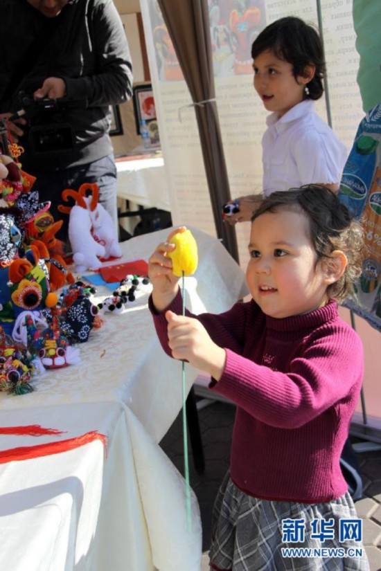 Ребенок в городе Алматы (Казахстан) рассматривает китайские изделия народного промысла (17 сентября 2013 года).