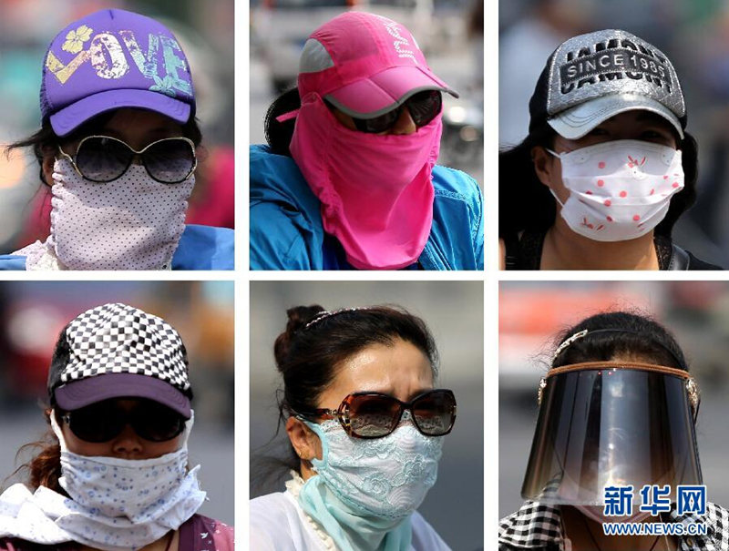 13 июля жители города Ляньюньган провинции Цзянсу ходят по улице в полном солнцезащитном снаряжении.