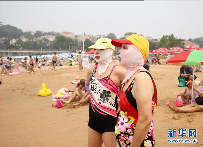 13 июля на пляже города Циндао во время купания люди покрывают своё лицо специальной маской, чтобы защищать от солнца.
