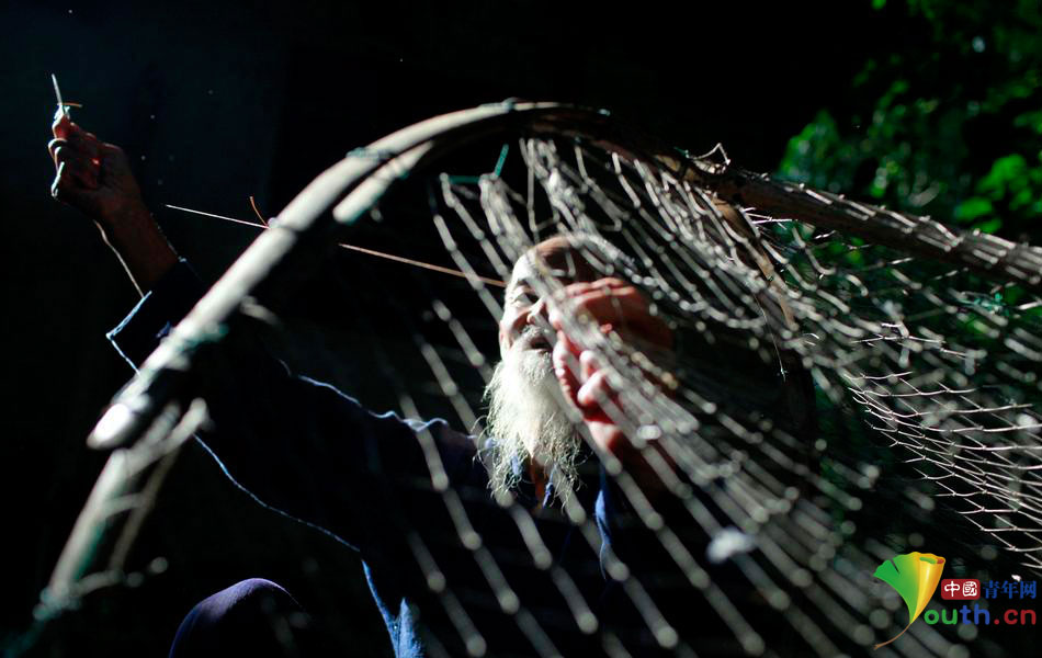Хуан Цюаньдэ чинит рыболовные сети