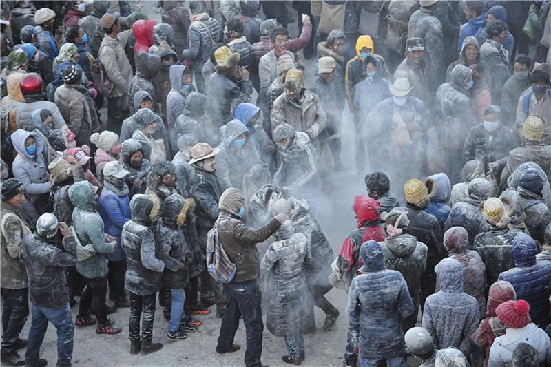 Жители тибетского города Шигацзе посыпают друг друга ячменной мукой “дзамба” для встречи Нового Года