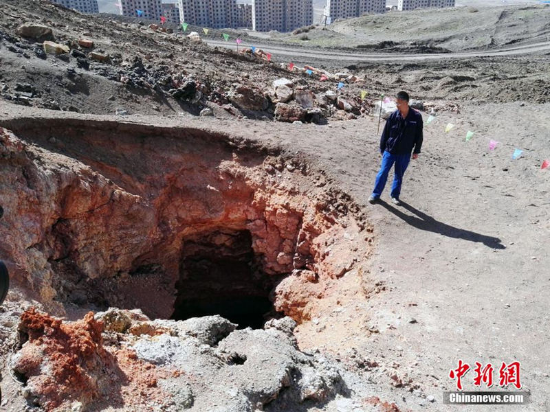 На фото: 6 апреля, инструктор инженерного бюро Синьцзянского угольного бассейна Мо Синьвэнь рассматривает "кратер" глубиной более 130 метров, образовавшийся в результате самовозгорания угля.