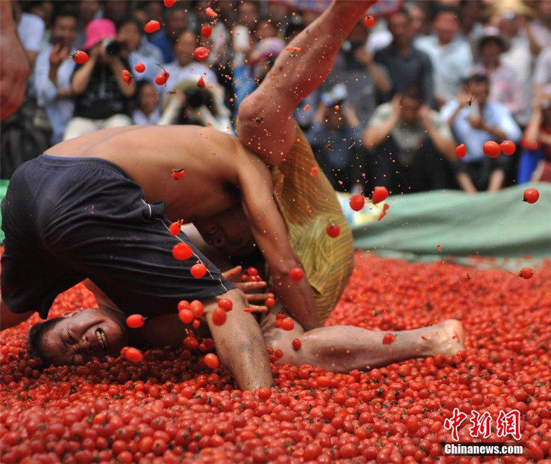 Люди народности Чжуан провели состязание в бассейне, наполненном помидорами черри