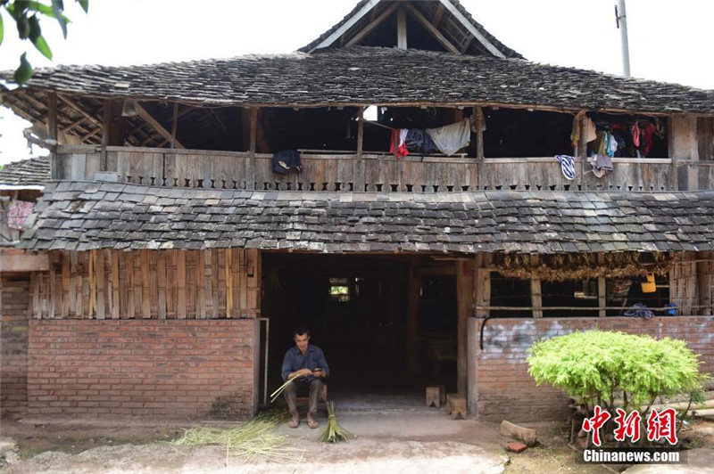 На фото: Мужчина плетет бамбуковое изделие. В селе народности Дай в изобилии растет бамбук, поэтому жители умеют плести из бамбука корзины, столы, стулья и многое другое.