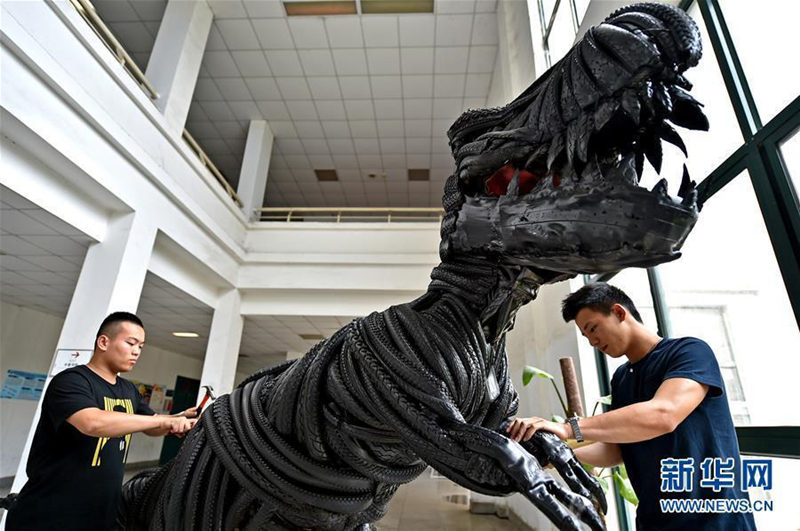 На фото: Студенты Лоянского педагогического института вносят поправки в модель "шинного динозавра".