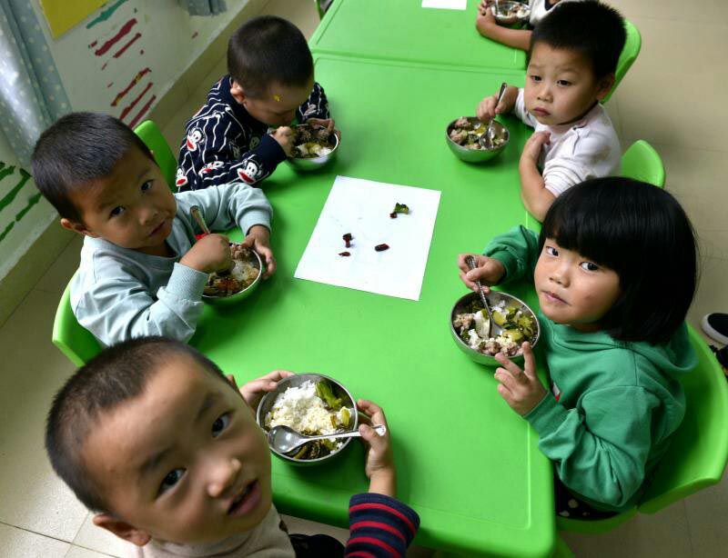 На фото: дети в Центральном детском саду в Динвэй-Шуйской национальной волости едят питательный обед. Источник фото: Сайт vip.people.com.cn