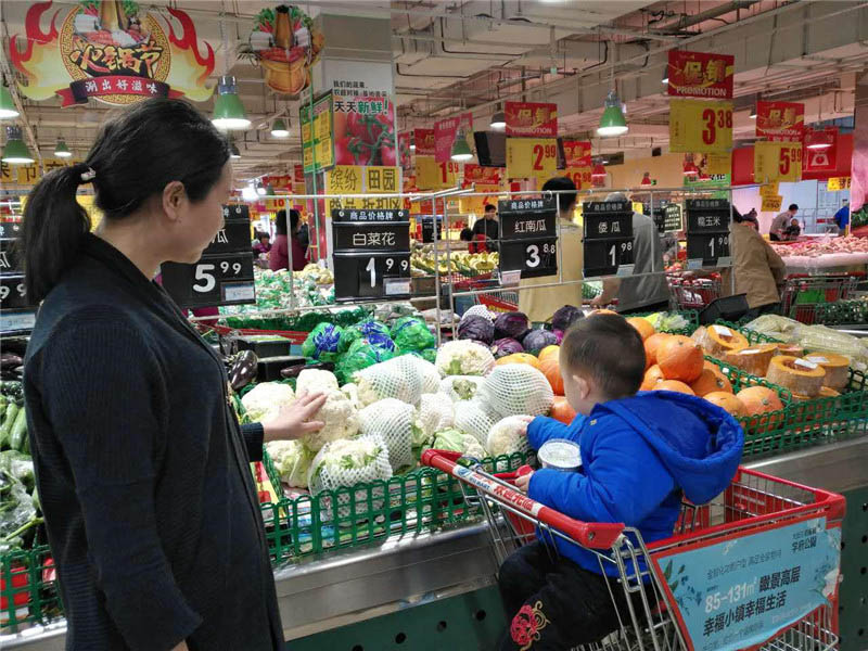 На фото: Покупатель выбирает овощи в пекинском супермаркете. Фотограф - корреспондент газеты «Жэньминь жибао» Чжан Мэнсюй.
