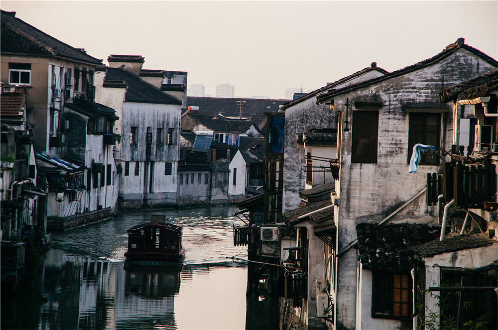 каналы современного СучжоуДата съемки: январь 2017 года.Место съемки: Китай, г. СучжоуСучжоу славится тем, что город буквально изрезан водными каналами, по которым уже не одну сотню лет идёт передвижение пассажиров и грузов. Отсутствие слепящих красок в архитектуре домов, которые кажется простоят еще не один десяток лет, лодка, рассекающая воду, безмятежность и чувство гармонии вдали от городской суеты – все это можно найти, лишь повернувшись лицом в одному из каналов этого города.