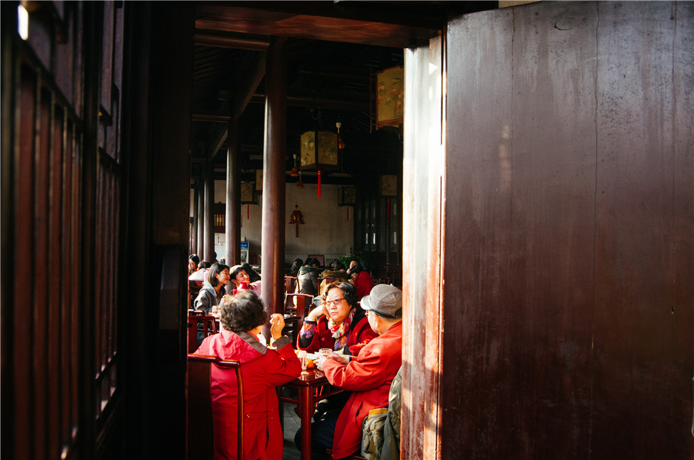 обеденное чаепитие Дата съемки: январь 2017 года.Место съемки: Китай, городской парк в г. СучжоуВ одном из небольших парков среди узких улочек «старого города» в Сучжоу можно наблюдать как множество людей разных возрастов ведут светские беседы за ланчем и обеденным чаем. Убранства парка построены в традиционном стиле в красных цветах с белыми стенам, за которыми не звука, пока не подойдешь к двери.