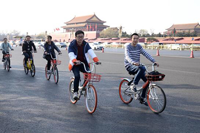 На фото: 10 марта 2017 года, по пекинской улице Чананьцзе едут люди на велосипедах общего пользования. На столичных улицах повсюду можно увидеть таких велосипедистов, в одном лишь Пекине насчитывается более 200 тыс общих велосипедов. Фото: "Жэньминьван"