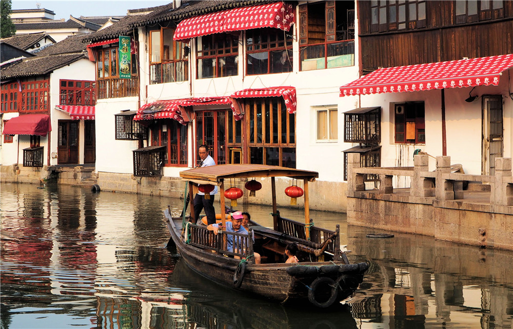 "По пути в Восточную Венецию" -﻿ Китайская семья проплывает мимо в "городе на воде" Чжуцзяцзяо.Место: Чжуцзяцзяо, Шанхай (август 2014 г.)