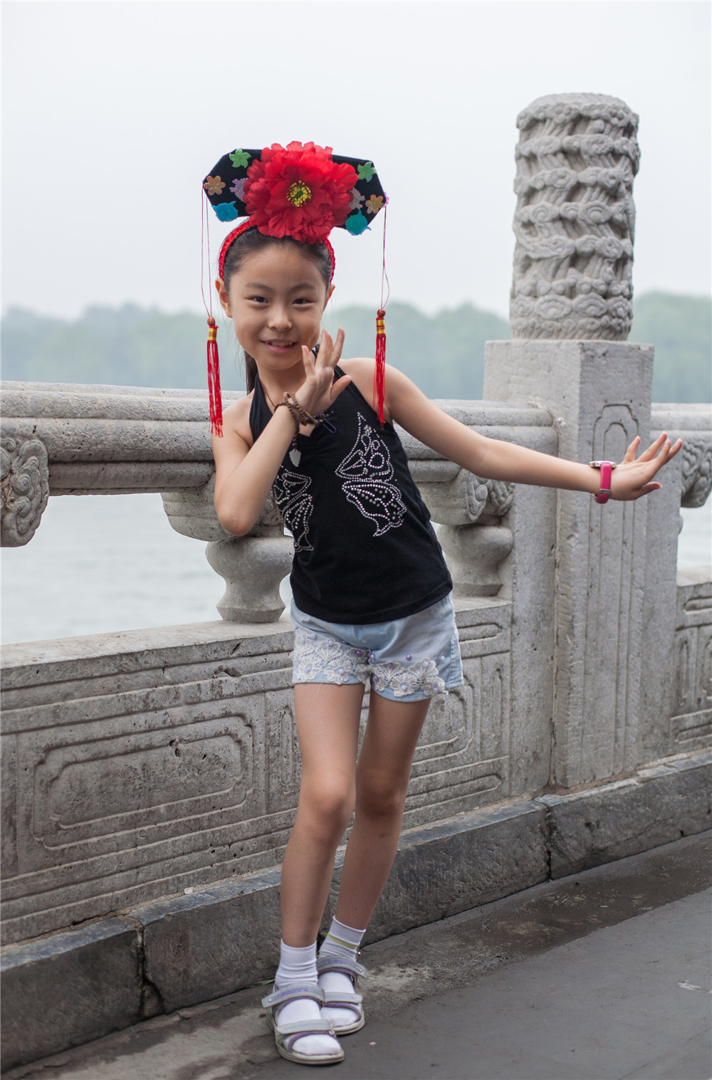 11 июля 2010г. Пекин, парк Бэйхай.Девочка в национальном головном уборе очень красиво позировала на фоне древнего каменного моста в праке Бэйхай.