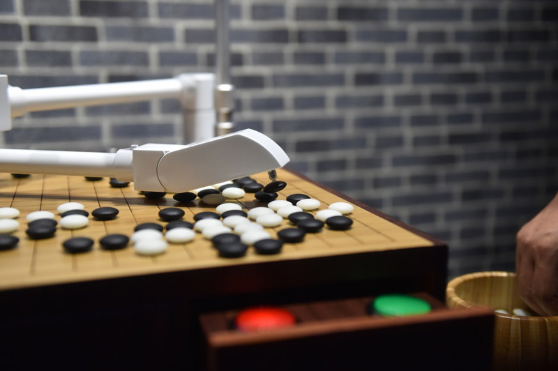 На фото: Робот играет в китайские шашки с посетителем.