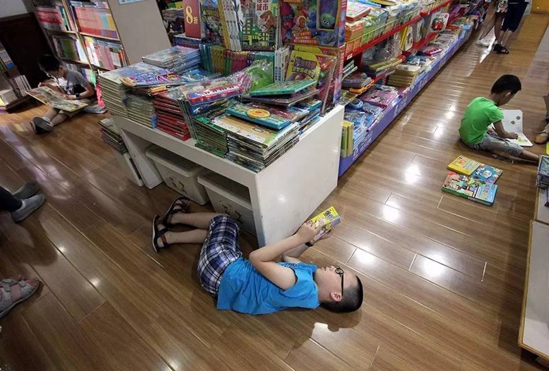Дети наслаждаются прохладой в книжном магазине. 