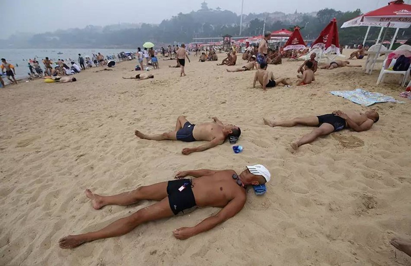 Туристы отдыхают на пляже в Циндао. 