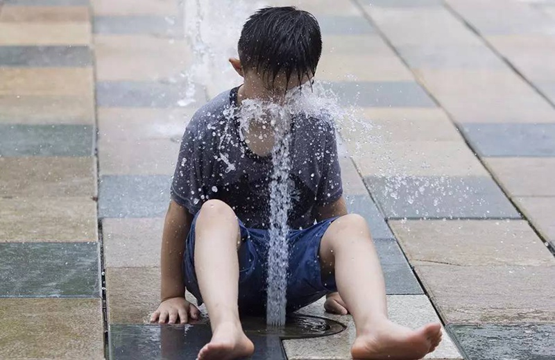 В Пекине мальчик охлаждается в фонтане. 