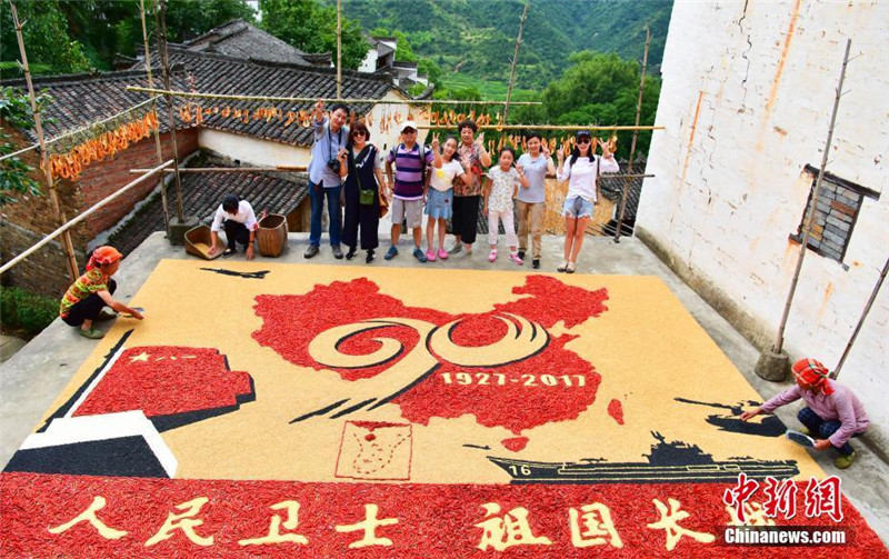Жительница китайской деревни составила картину из сельскохозяйственных культур в честь Дня НОАК