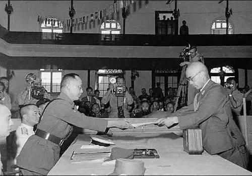 9 сентября 1945 года, в Нанкине главнокомандующий японскими войсками в Китае Окамура (справа) передал протокол о капитуляции китайскому главнокомандующему сухопутными войсками Хэ Инциню.  