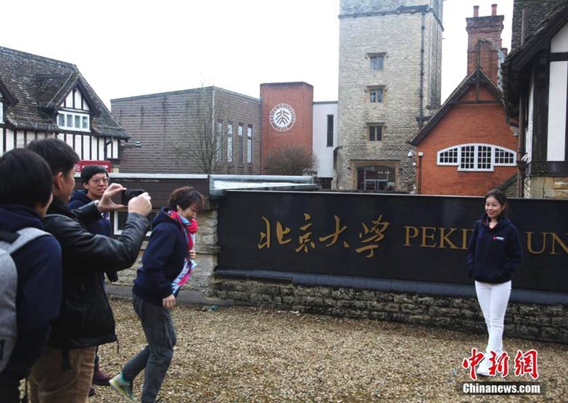 Студенты фотографируются перед вывеской кампуса Пекинского университета в Оксфорде.