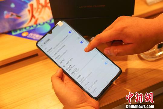 На фото: 27 июля в городе Тайюань провинции Шаньси работник компании Huawei показывает коммерческий смартфон 5G Huawei.