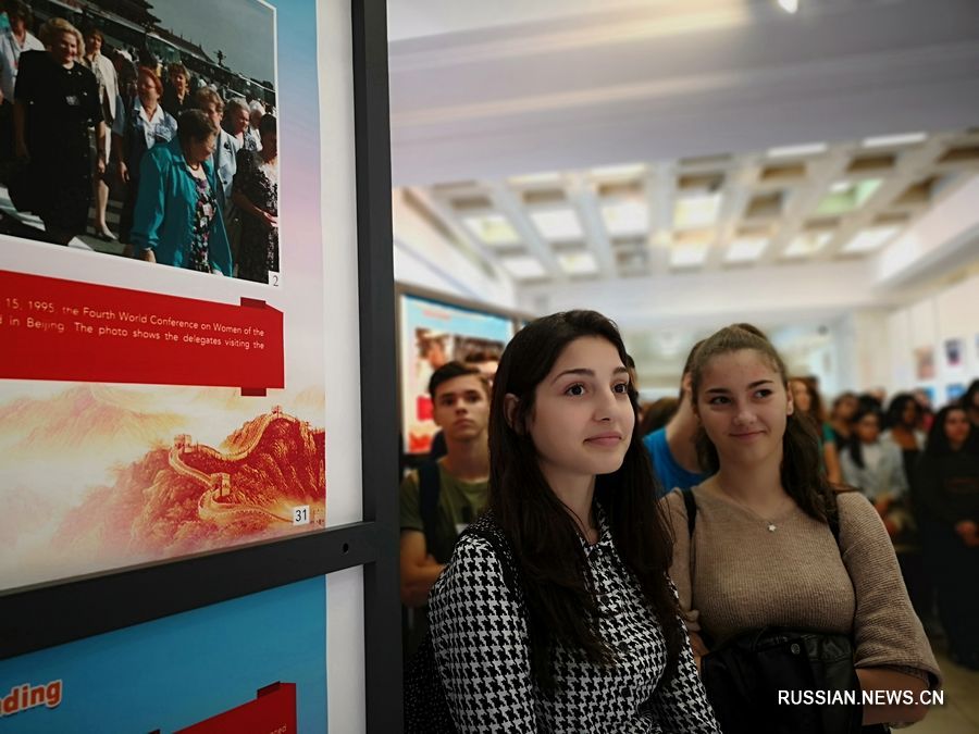 14 октября в Бухаресте две студентки принимают участие в церемонии открытия международной передвижной выставки, посвященной 70-летию образования КНР. /Фото: Синьхуа/