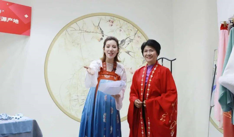 На фото: Заместитель секретаря парткома и начальник уезда Цао Лян Хуэйминь (правая) и ведущая (левая) продают ханьфу в прямом эфире