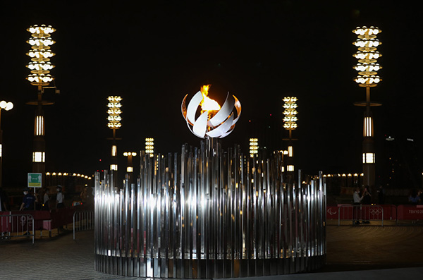 Чаша с олимпийским огнем украшает ночь в Токио