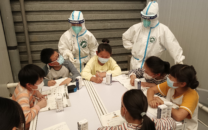В этом временном госпитале Шанхая доктора медицинских наук консультируют детей по их домашним заданиям