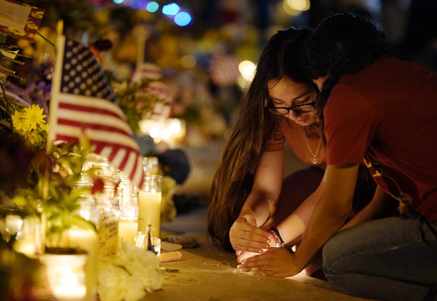 29 мая, Ювалд, штат Техас, США. Девушки зажигают свечи в память о жертвах массовой стрельбы в школе на городской площади. /Фото: Синьхуа/