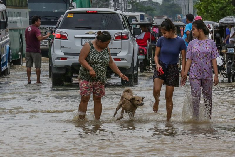 26 сентября, провинция Булакан, Филиппины. Местные жители на затопленной улице. /Фото: Синьхуа/