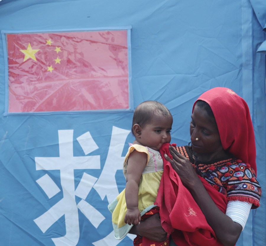 29 сентября, Матли, Пакистан. Женщина с ребенком у предоставленной Китаем палатки. /Фото: Синьхуа/