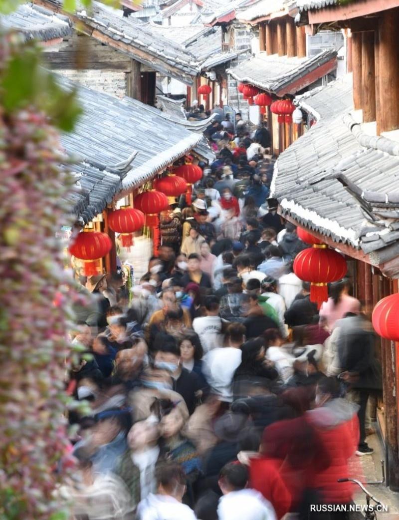 24 января 2023 года, туристы прогуливаются в старом городе Лицзян в пров. Юньнань на юго-западе Китая. /Фото Синьхуа/