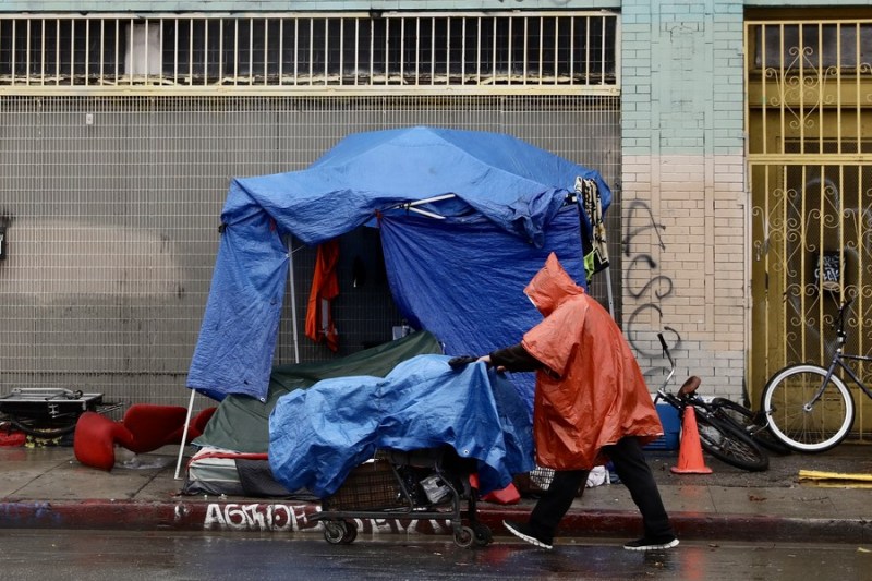 10 января, Лос-Анджелес, США. Бездомный человек идет под дождем по 6-й улице в центре Лос-Анджелеса. /Фото: Синьхуа/