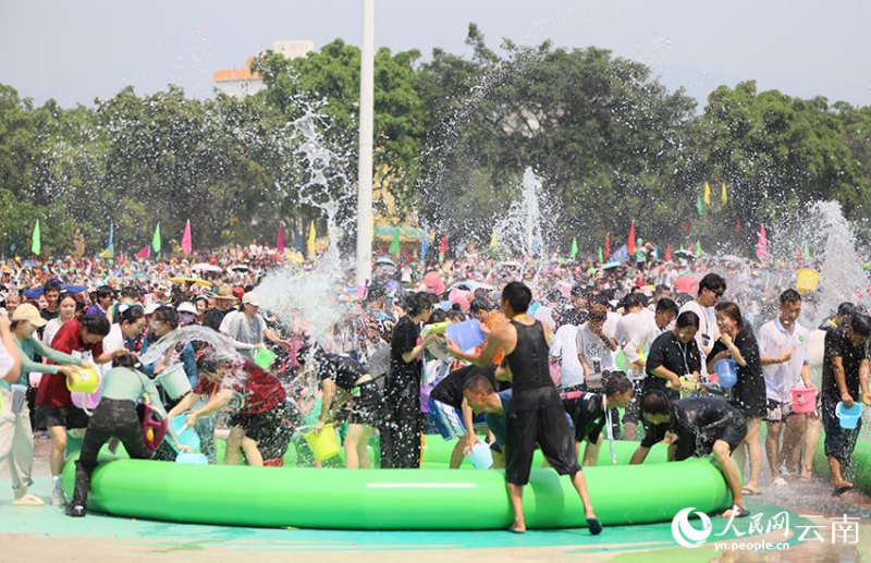 Десятки тысяч человек отмечают праздник обливания водой в городе Манши Юньнаня