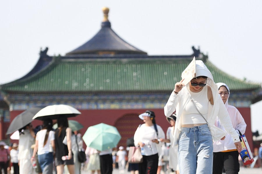 23 июня 2023 года, туристка закрывается от солнца бумажным пакетом в Храме Неба в Пекине. /Фото: Синьхуа/