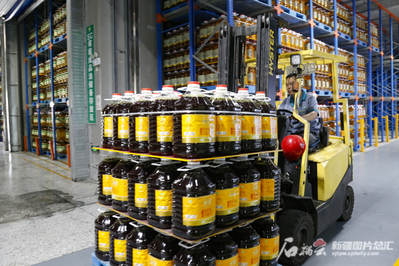 25 августа 2023 года в сианьской компании «Айцзюй» сотрудник управляет вилочным погрузчиком для перевозки на склад для хранения пищевых масел, которые только что сошли с производственной линии.