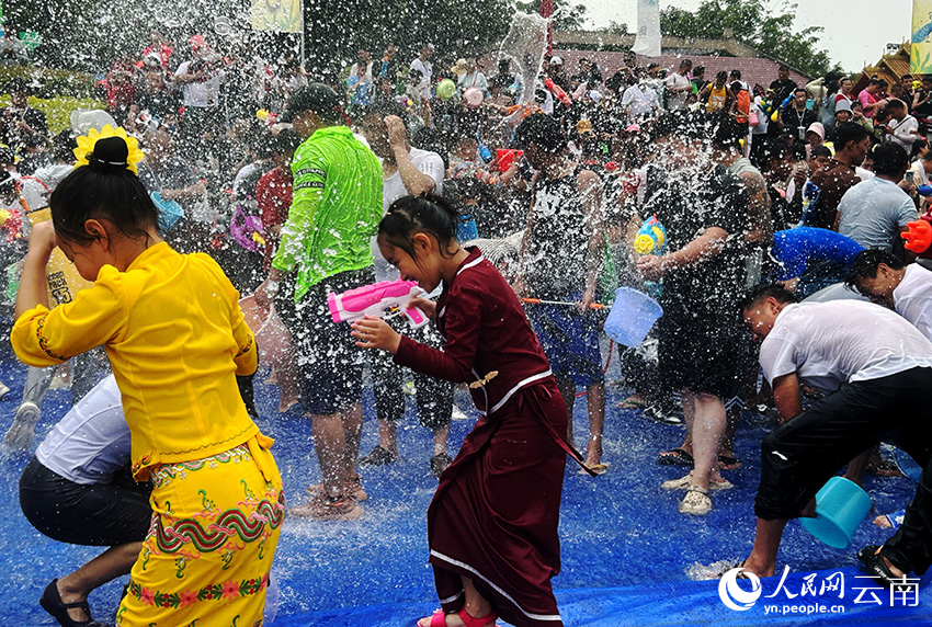 В городе Манши провинции Юньнань тысячи людей отмечают Фестиваль водных брызг