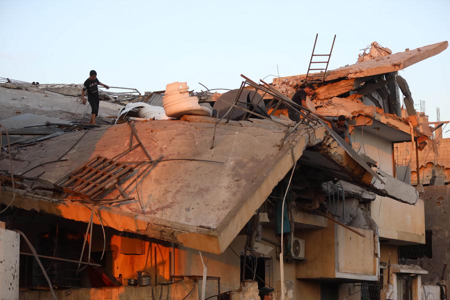 15 июля, сектор Газа. Люди осматривают разрушенное в результате израильского авиаудара здание в лагере беженцев Аль-Магази в центральной части сектора Газа. /Фото: Синьхуа/