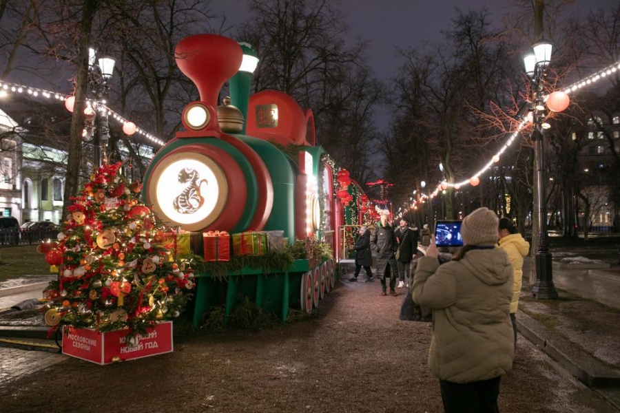 28 января, Москва. Женщина фотографирует инсталляцию поезда с украшениями по случаю праздника Весны в центре Москвы. /Фото: Синьхуа/ 