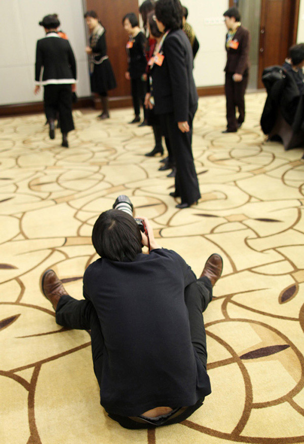21 января 2013 года фотожурналист, сидя на полу, делает снимки танцующих членов НПКСК.
