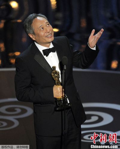 Счастливый режиссер Энг Ли ест гамбургер на улице с  "Оскаром" в руке (2)