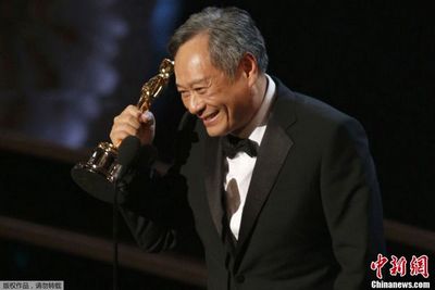 Счастливый режиссер Энг Ли ест гамбургер на улице с  "Оскаром" в руке (3)