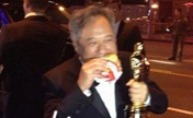 Энг Ли ест гамбургер с "Оскаром" в руке