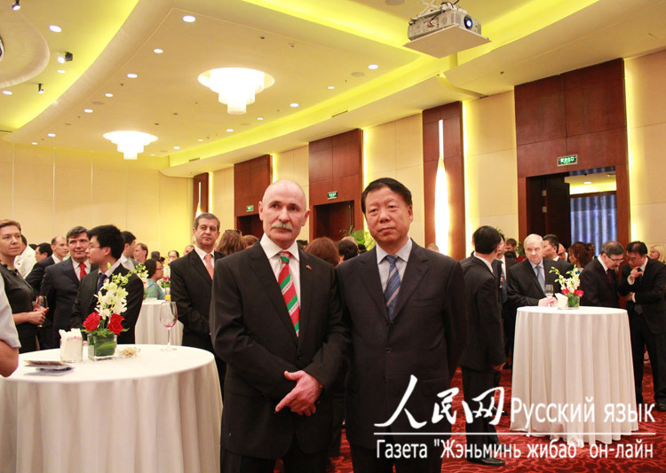 Посол Республики Беларусь в КНР Виктор Буря (слева) вместе с заместителем заведующего международным отделом ЦК КПК Чэнь Фэнсяном (справа) наслаждаются выступлением белорусских артистов
