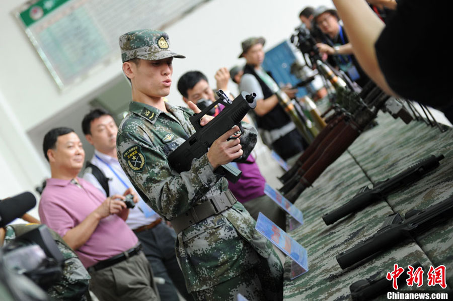На фото: военнослужащий НОАК демонстрирует журналистам мини-автомат